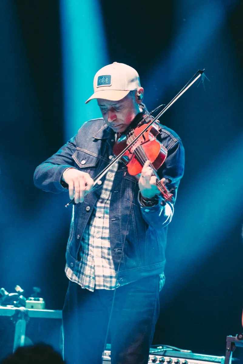 Big Holler's fiddle player mid-song under teal stage light